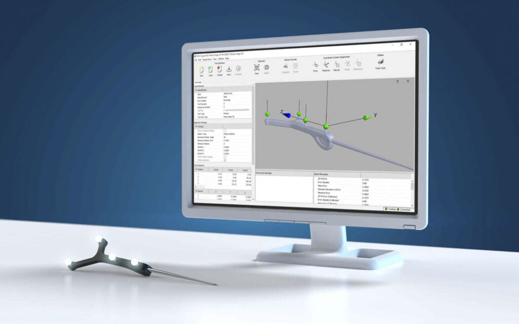 Polaris software on a monitor showing a tracked tool with markers and 3D coordinate axes, with a probe with markers in front of it.