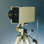 The OPTOTRAK 3010 optical measurement system, an early single-lens tracking unit mounted on a tripod. Released in 1988.